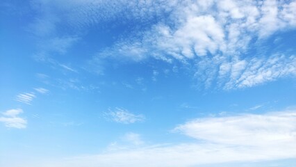 Fototapeta premium Beautiful bright blue sky with white wispy cirrus clouds background.