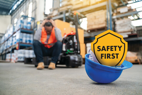 Safety First Warehouse worker sits on the floor after a safety incident near a forklift; hard hat and PPE, accident prevention, risk management, and compliance training.