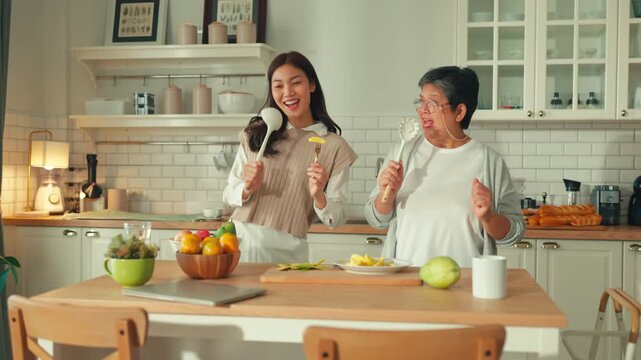Happy mother's day teen daughter and mom laughing dance enjoy parenting activity relationship fun in the kitchen at home. Family holiday and togetherness Happy female family having fun on weekend 