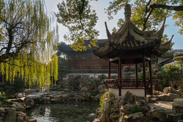 Toasting Pavilion on the shore of the pond and the Deyue Hall in the background in the Yuyuan Garden (Yu Garden) on a sunny day, Shanghai, China
