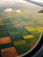 Vibrant Patchwork of Fields Unfolds Beneath a Plane During a Serene Afternoon Flight Over Rural Landscapes