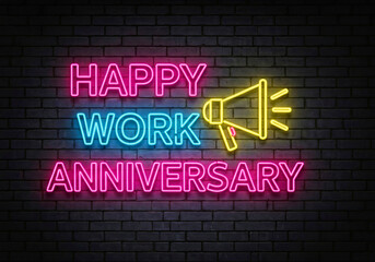 Neon sign displaying "Happy Work Anniversary" with vibrant pink and blue text. A yellow megaphone adds a celebratory tone on a dark brick background.