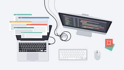 Modern computer setup on a clean desk featuring laptop, monitor, keyboard, and scattered documents in a productive workspace.