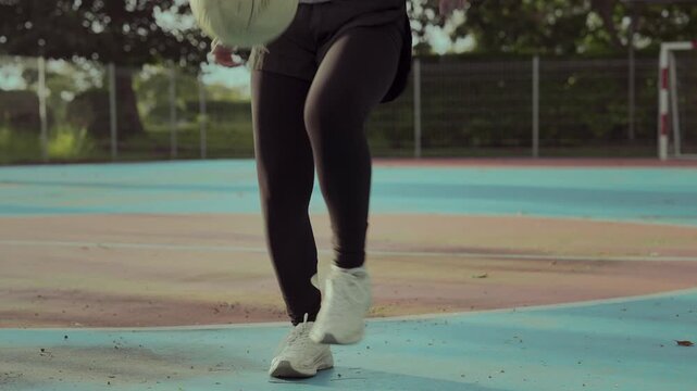 Asian girl playing futsal football outdoor.