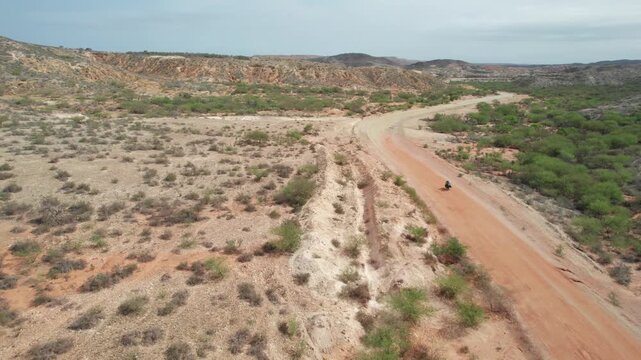 Aerial Drone View of Motorcyclist on Dirt Road in Araya Venezuela