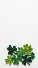 A Beautiful Collection of Quilling Art: Green and Yellow Paper Shamrocks Displayed on a White Background for St. Patrick's Day Celebrations