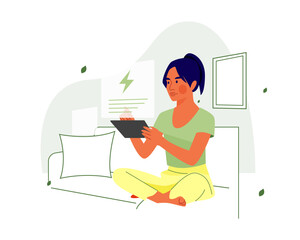 Young Woman Sitting on Sofa Using Digital Tablet for Smart Home Energy Management