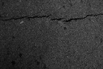Close-up acro shot of road surface cracks highlighting worn asphalt and fracture lines.