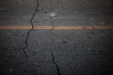 Detailed close-up of a damaged road surface with visible cracks and rough texture.