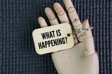 Wooden tag with the question word what is happening? an event or occurrence.