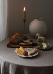 Breakfast is served on the table - bread, cheese, egg, butter on the table with a gray tablecloth