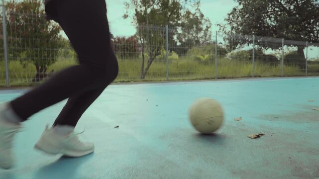 Asian girl playing futsal football outdoor.
