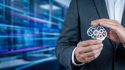 Business high level planning concept with artificial intelligence icon in hand near data server room technology background