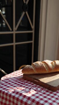 Warm, cozy morning scene with bread and coffee on a checkered tablecloth. Captured from a side angle, perfect for a breakfast-themed video.