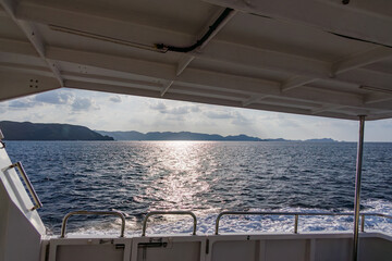 Obraz premium 周囲の島々を繋ぐ、村営連絡船「みつしま」。 沖には多くの無人島が浮かんでいる。 座間味港 座間味島沖縄県島尻郡慶良間諸島-2025 沖縄本島から40km西方にある諸島。 大小30以上の島々からなる島嶼群は全体が国立公園に指定されている。 珊瑚礁の海、白い砂浜、緑の山地は世界屈指の美しさ。 多くの貴重な動植物が生息している。 