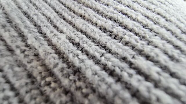 Macro shot of grey knitted wool fabric texture with detailed stitching