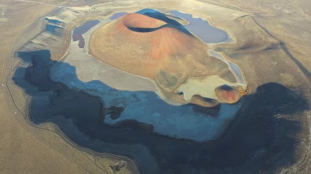 Aerial view of tuff ring cone and volcanic crater lake maar in a barren caldera of Konya Turkiye. Beautiful arid Anatolian desert terrain shows a dry geologic basin viewed from above without trees.