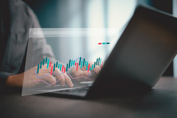 Person typing on laptop with digital stock market candlestick chart overlay
