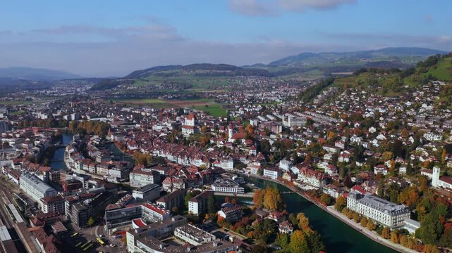 Thun Castle Aare River aerial drone Schloss Thun Thunersee Switzerland Schweiz Europe Autumn Fall cityscape pedestrian walkway sunny blue sky clouds yellow birches tree Bernese Oberland forward motion