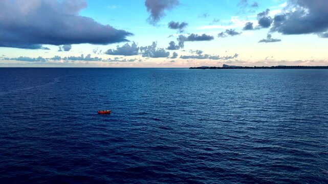 Traditional subsistence fishermen rowing wooden boat off Mauritius coast