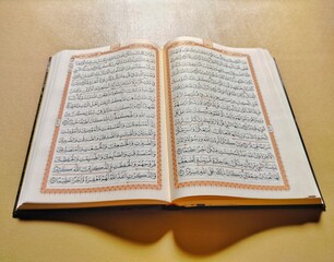 Obraz premium open the holy qur'an with arabic text on brown background 