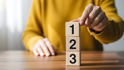 Person stacking wooden blocks with numbers 1 2 3
