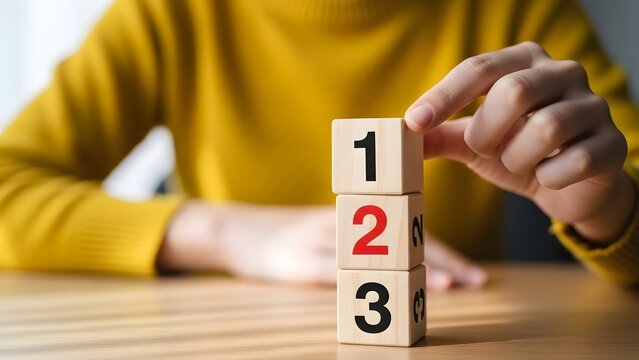 A person stacking wooden blocks with numbers one two and three