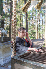 神社でお参りする着物姿の女性