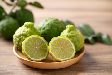 Kaffir lime fruit with leaf on wooden background, Thai food ingredient