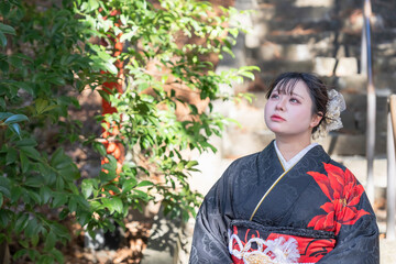 神社でお参りする着物姿の女性