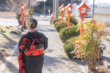 神社でお参りする着物姿の女性