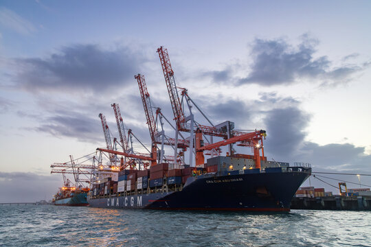 Cargo cranes and two large container ships at dusk. Photographed at the Port of Tauranga, New Zealand, December 31, 2025