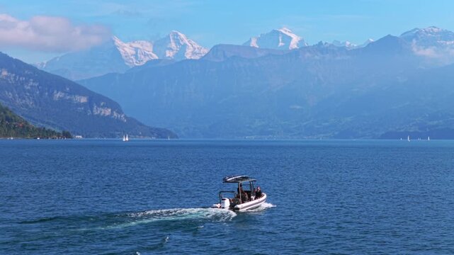 Powerboat Swiss Alps Grindelwald Jungfrau mountains Bernese Oberland Thunersee Lake Thun aerial drone Thun Switzerland Schweiz Fall Autumn sunny morning low clouds haze Interlaken follow motion