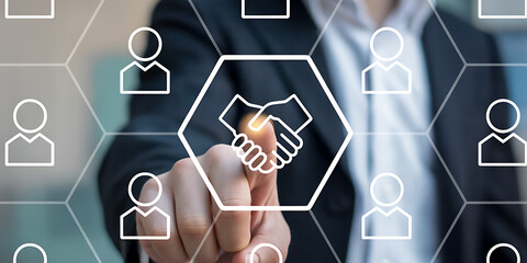 Digital concept of business collaboration with a human hand tapping a glowing handshake icon amidst a hexagonal network of user avatars.