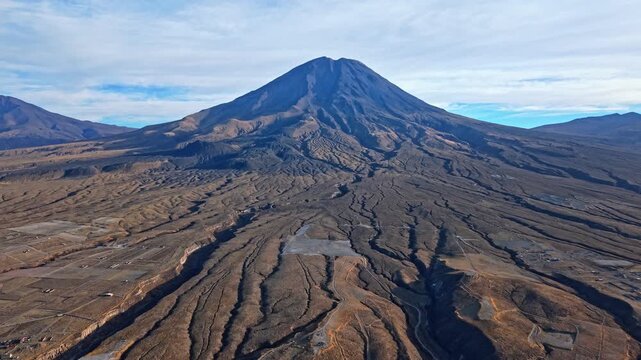 A reversing drone shot of Misti volcano near Arequipa, Peru, revealing massive lava flows spreading from the base of the volcano, showing the enormous scale of its last powerful eruption.