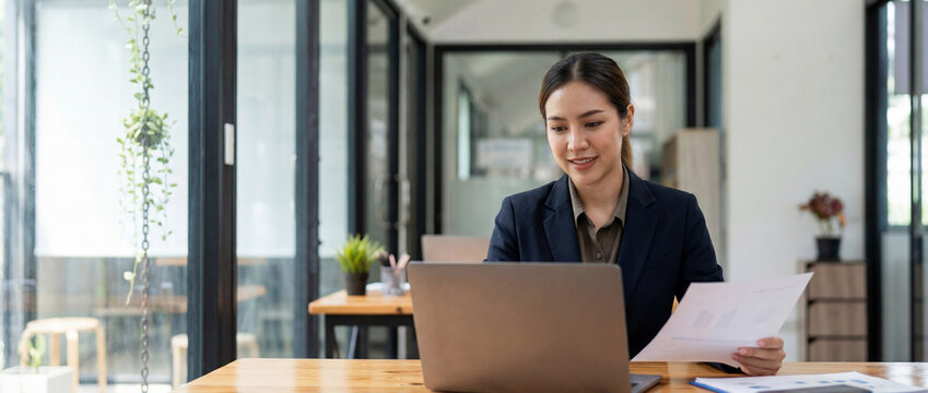 Focused latin business woman accountant working on laptop computer reading financial contract document in office workplace. Mature manager businesswoman specialist doing paperwork using pc. Copy space