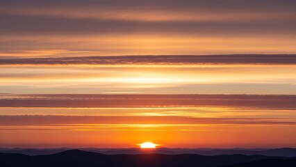 Majestic, vibrant sunset over distant mountain silhouettes