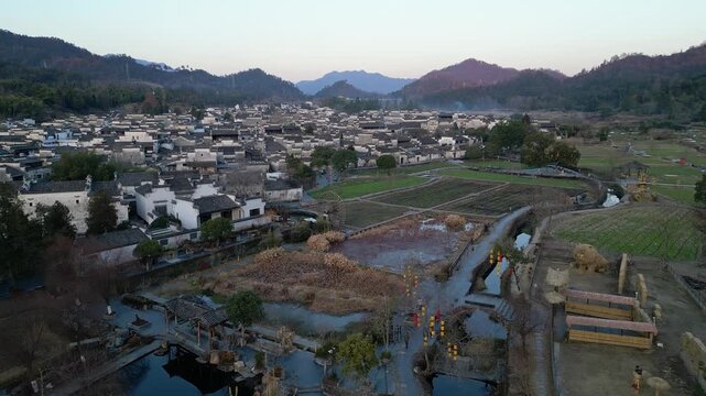 Xidi, China: Aerial drone footage of the famous Xidi ancient village in Anhui province in China. Shot at sunset above the field surrounding the village famous for old Hui architecture. 