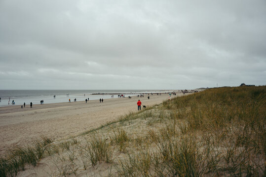 Viele Besucher gehen im Herbst am langen Strand entlang