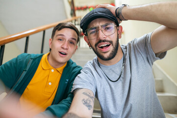 Two men friends taking selfie looking surprised