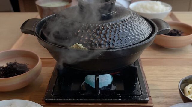 湯気が出ている土鍋の動画。食材を煮込んでいる熱々の鍋料理。