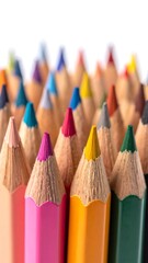 Fototapeta premium Many colorful pencils stand together, points up against a white backdrop, blurring into the background