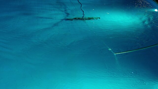 Cleaning the pool bottom with a water vacuum cleaner in the evening. The concept of cleaning pools for hotels, resorts and country houses.