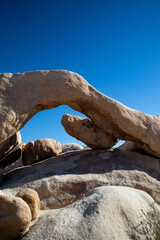 Granite arch formation against vibrant blue desert sky