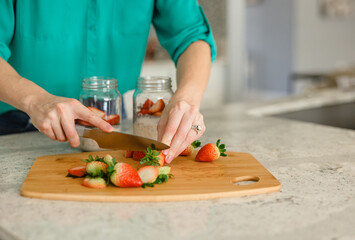 Busy Mom Chopping Strawberries on Wooden Board