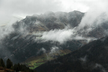 Moody fog and low clouds over a remote alpine valley in Switzerland