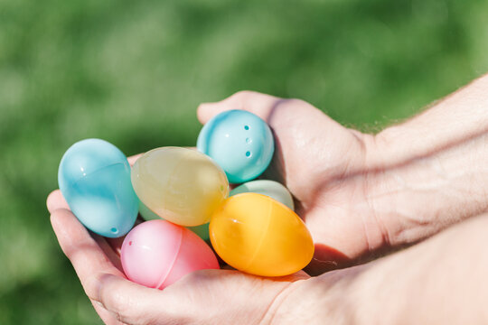 Hands holding plastic Easter eggs.