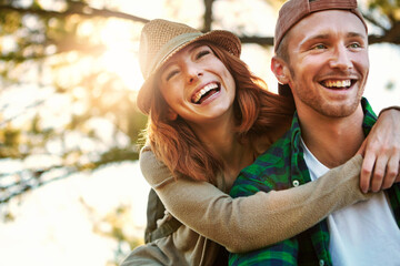 Love, smile and couple in nature with hug, bonding together and romance in sightseeing adventure. Flare, bokeh and happy people in forest with embrace, commitment and connection in outdoor trip.