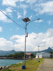 solar powered street light mounted on a metal pole with solar panel, control box, and electrical...