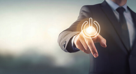 Businessman hand pointing to activate a glowing power on/off symbol. Concept of start, new beginnings, technology, and digital energy on a virtual interface